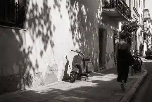 Sunlit Mediterranean street with a vintage scooter